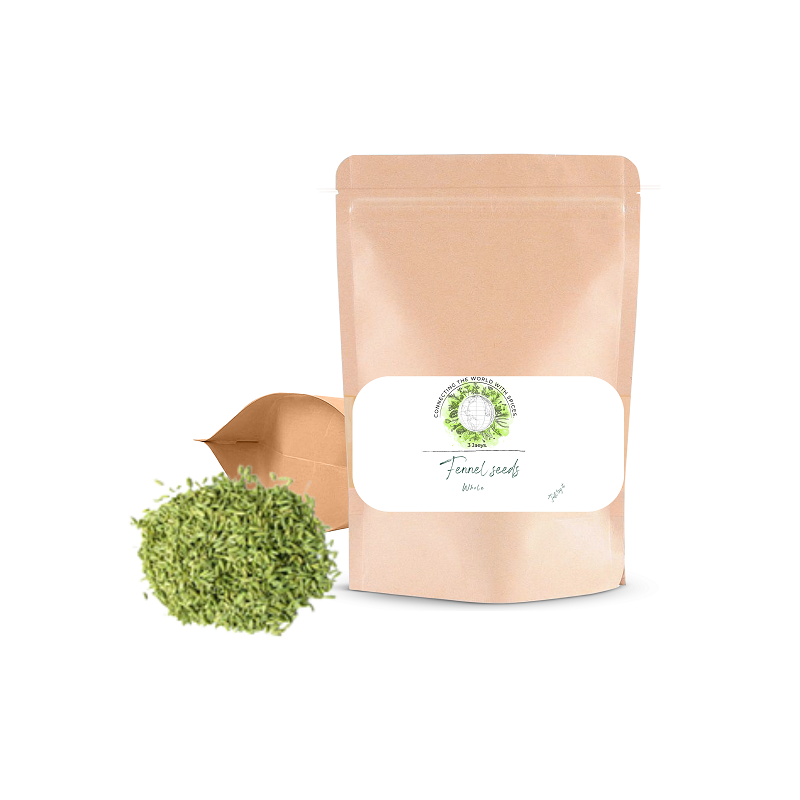 A small open bag of fennel seeds displaying the product name and quantity on a label, with a few green fennel seeds spilling out in front.